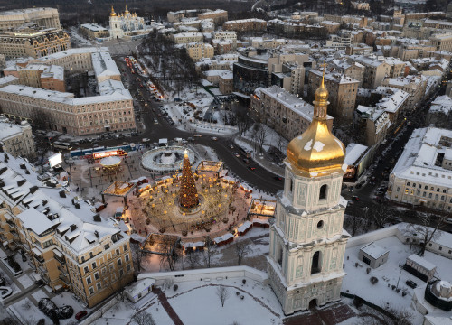 Snow covers the city center with the Christmas Tree, St.Sophia Cathedral in the foreground and St. M