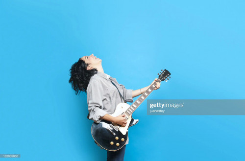 Guitar player against a blue background